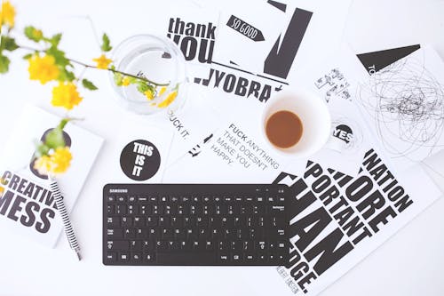 Top view of creative workspace with keyboard and coffee