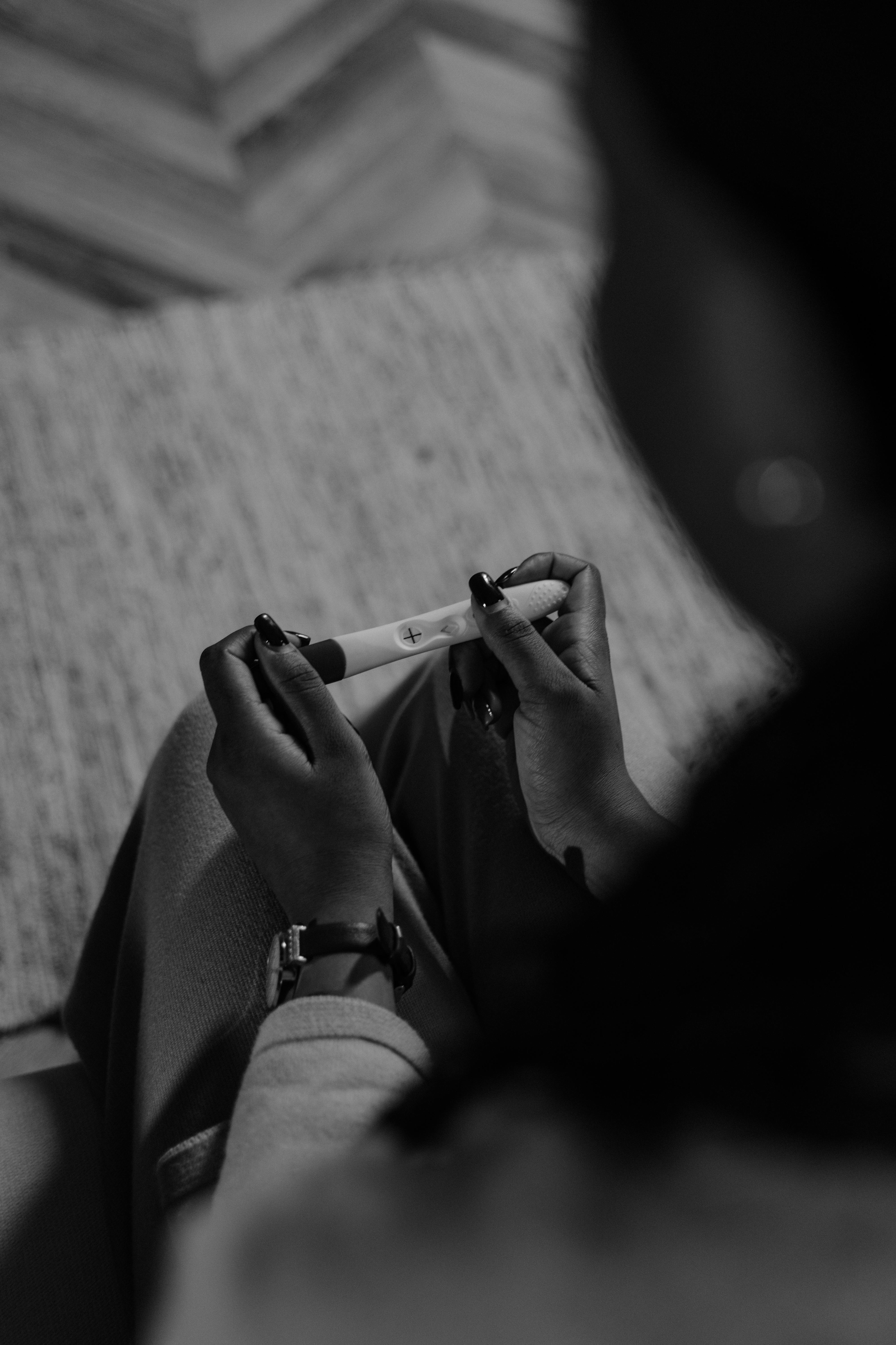 grayscale photo of woman looking at the result of pregnancy test