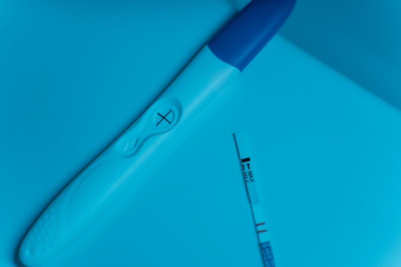 Positive pregnancy test on blue surface, symbolizing new beginnings and family planning.