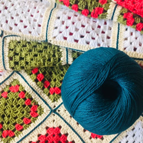 Blue Yarn Role on a Crochet Mat