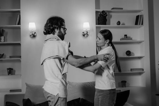 Man in White Shirt and Black Shorts Holding Woman in White Shirt