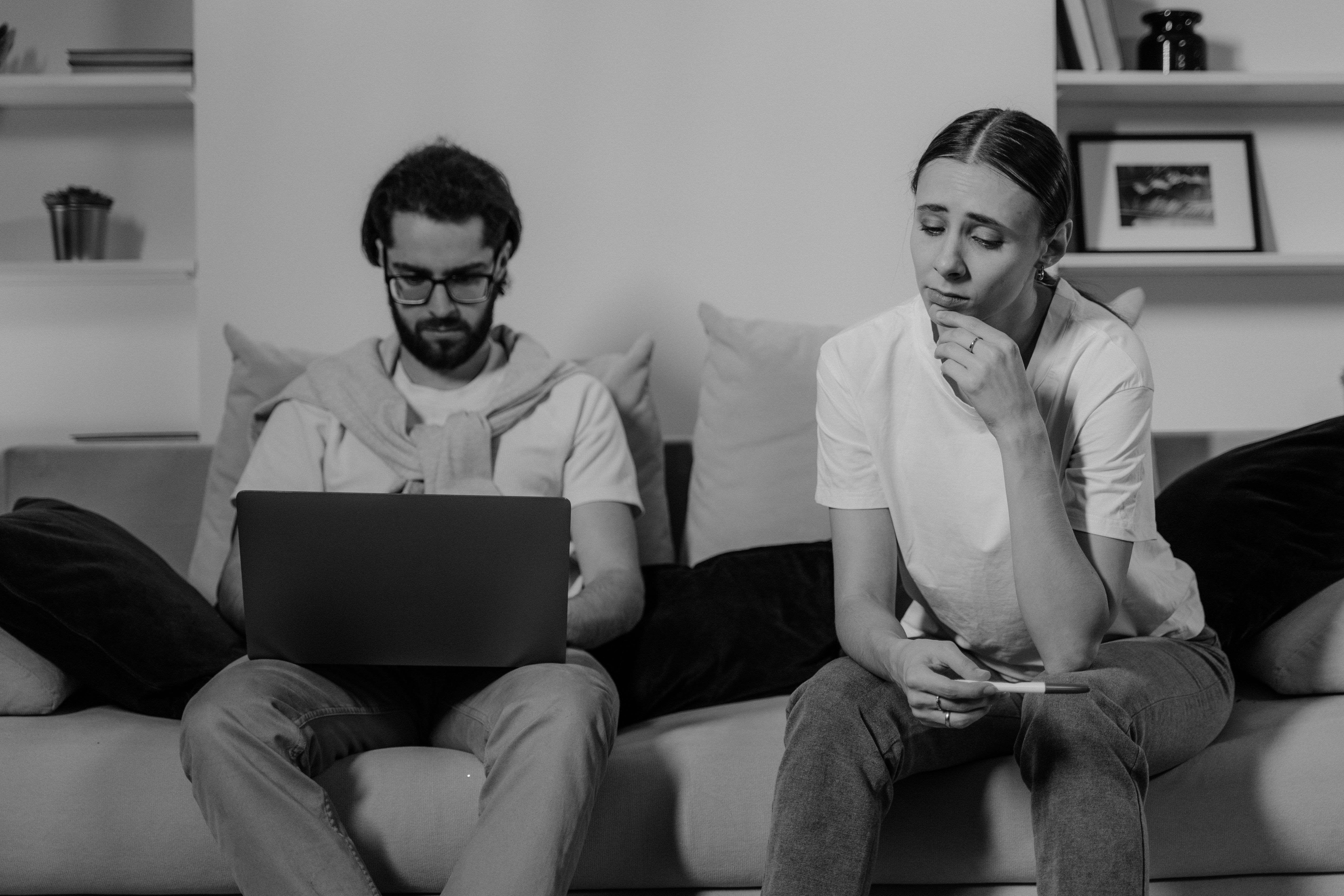 Staged emotional scene of a couple on a sofa; use of contrast and skin tones can shape mood.
