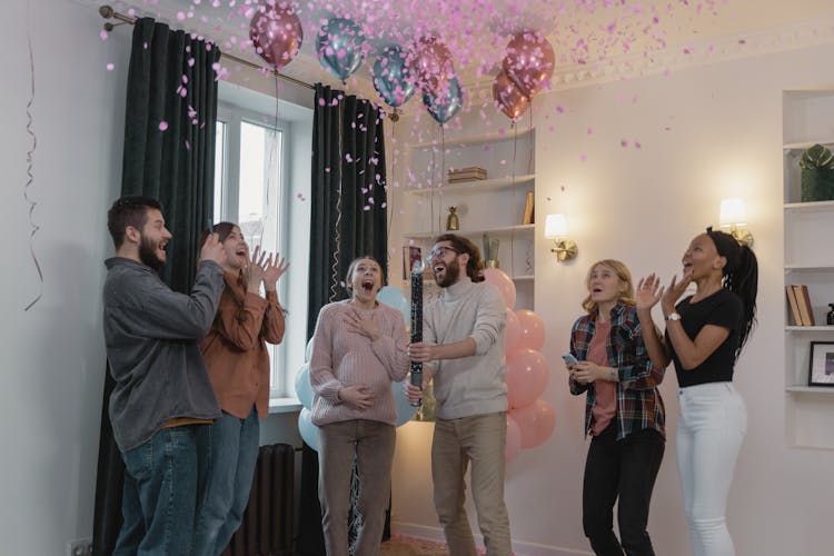 Happy People Looking At The Pink Confetti In The Air