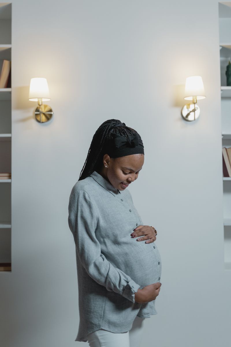 A Black pregnant woman in a long-sleeved shirt cradles her belly. Preeclampsia is more common and more deadly in Black women, and many cases give few warning signs before they turn dangerous.
