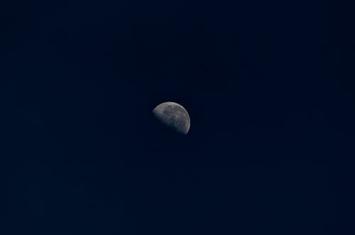 Free Half moon with stains in black sky at night Stock Photo