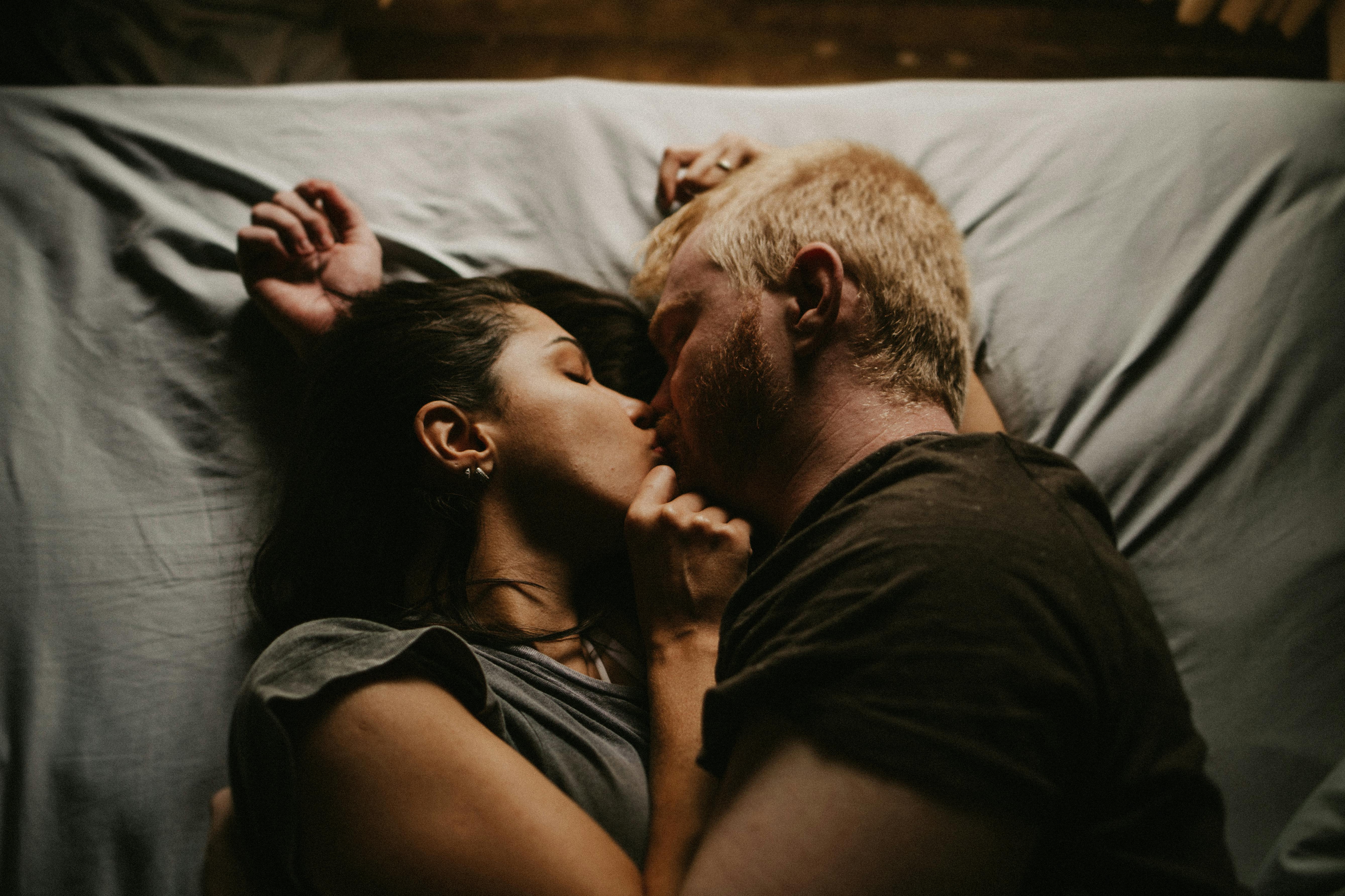 Man and Woman Lying on a Bed Kissing · Free Stock Photo