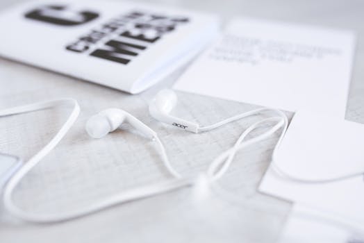 Close-up of white earphones with a modern minimalist aesthetic on a desk.