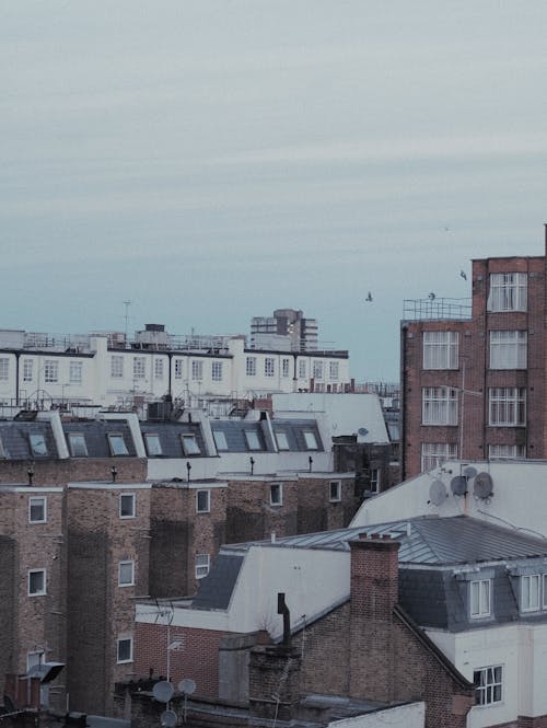 View of Rooftops of Concrete Buildings Under Gray Sky