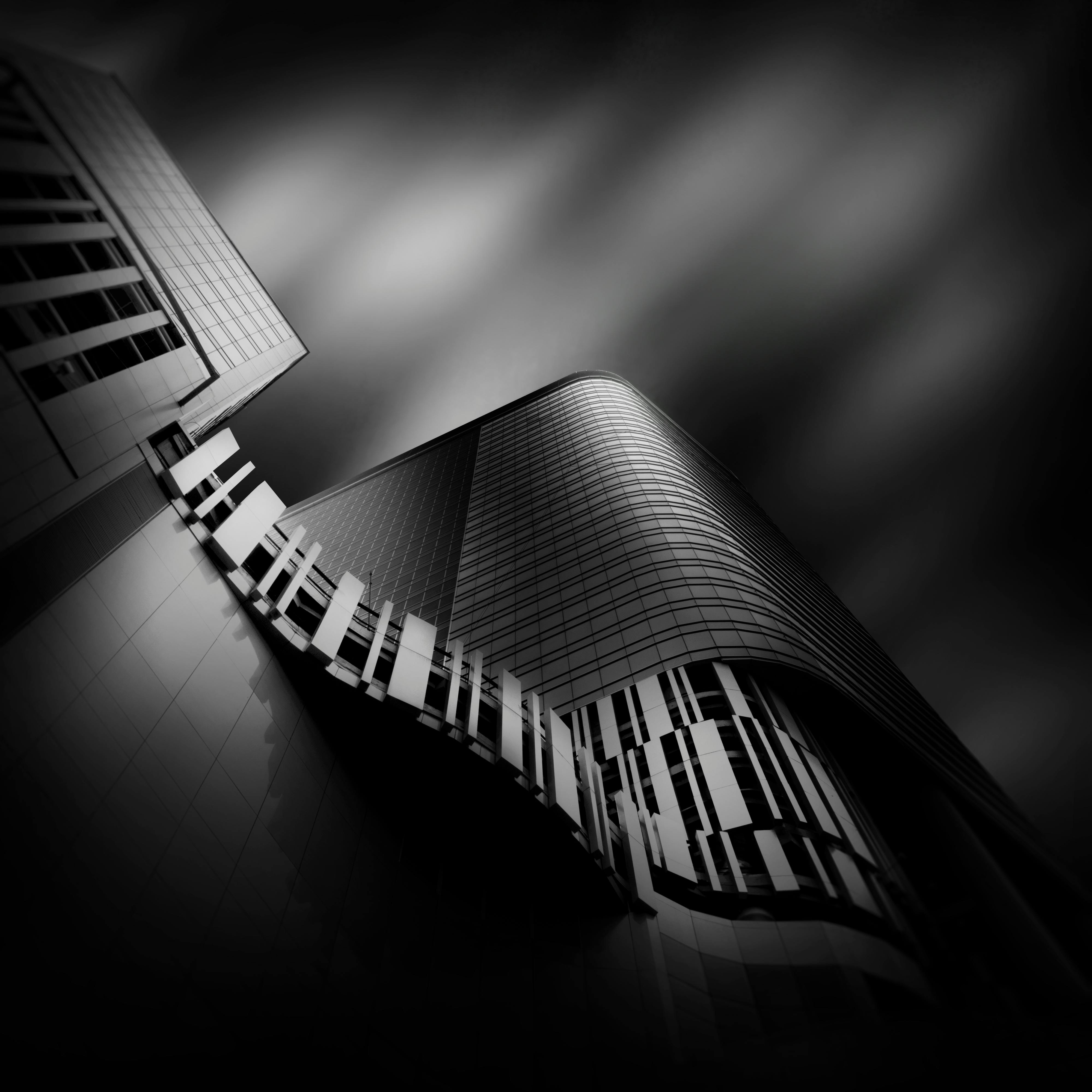 Futuristic black-and-white shot of a modern skyscraper with dynamic architecture.