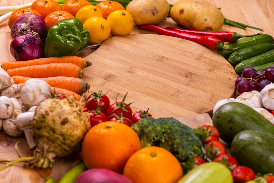 Fotomural Variedad vibrante de frutas y verduras frescas sobre una mesa de madera para una alimentación saludable.