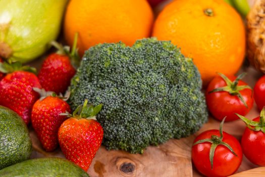 A vibrant collection of fresh, organic fruits and vegetables on a wooden table, showcasing healthy variety.