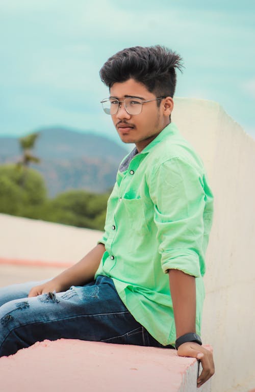 Man in Mint Green Long Sleeve Sitting on a Concrete Bench