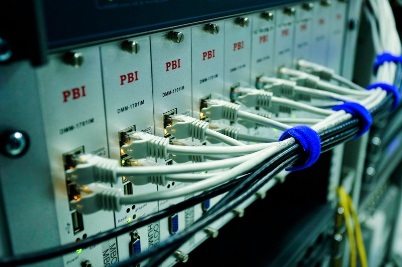 Close-up of ethernet cables connected to a network switch panel in a data center.