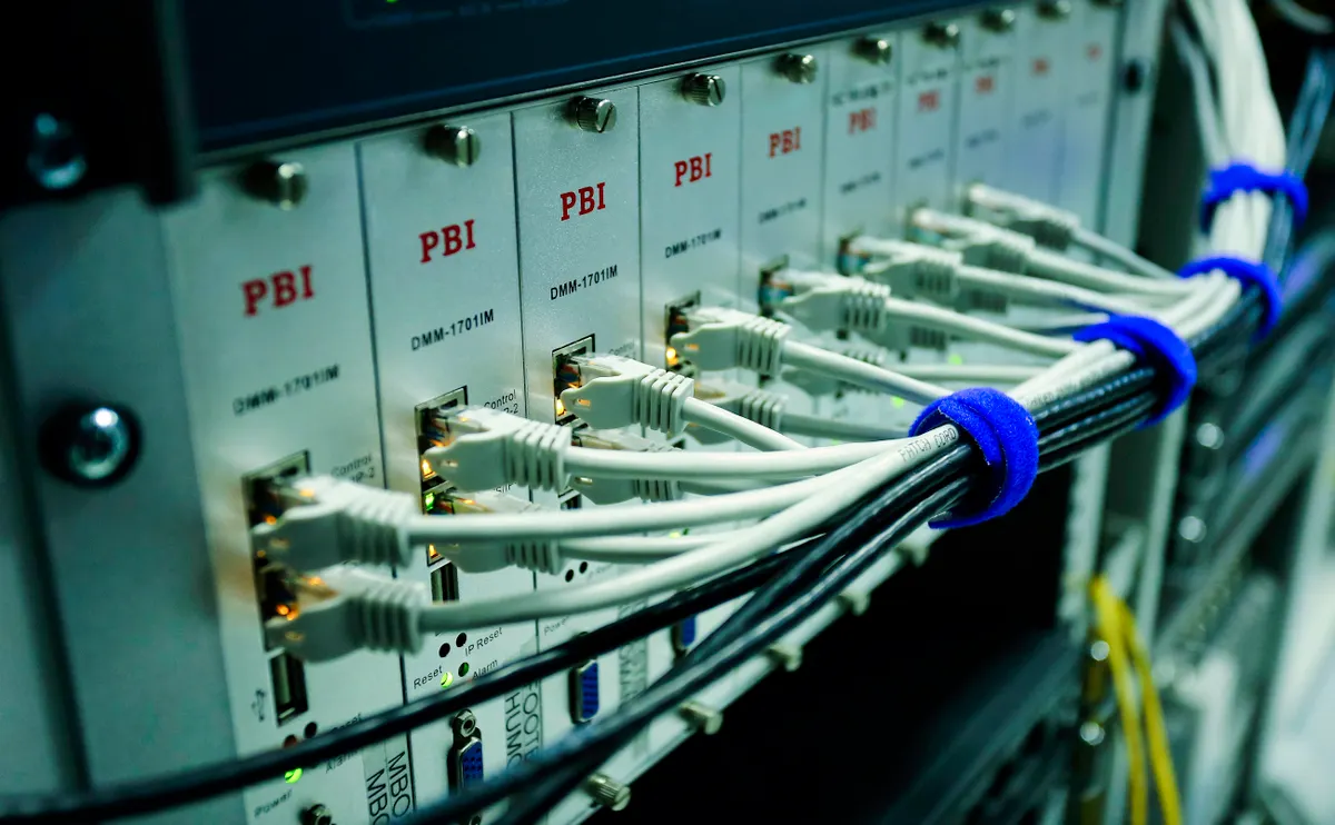 Close-up of ethernet cables plugged into a network switch, representing the authenticated webhook connection between a charting platform and a prop firm broker