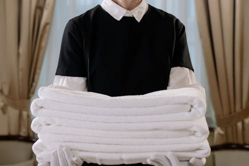 Free Person Holding a Stack of White Towels Stock Photo