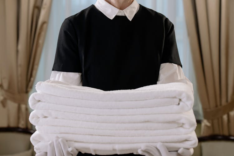 Person Holding A Stack Of White Towels