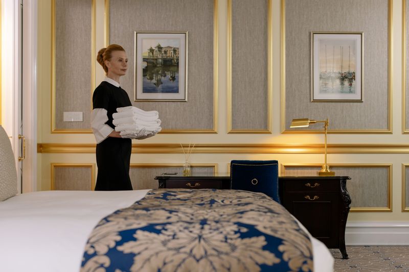 Housekeeper carrying a stack of fresh white towels