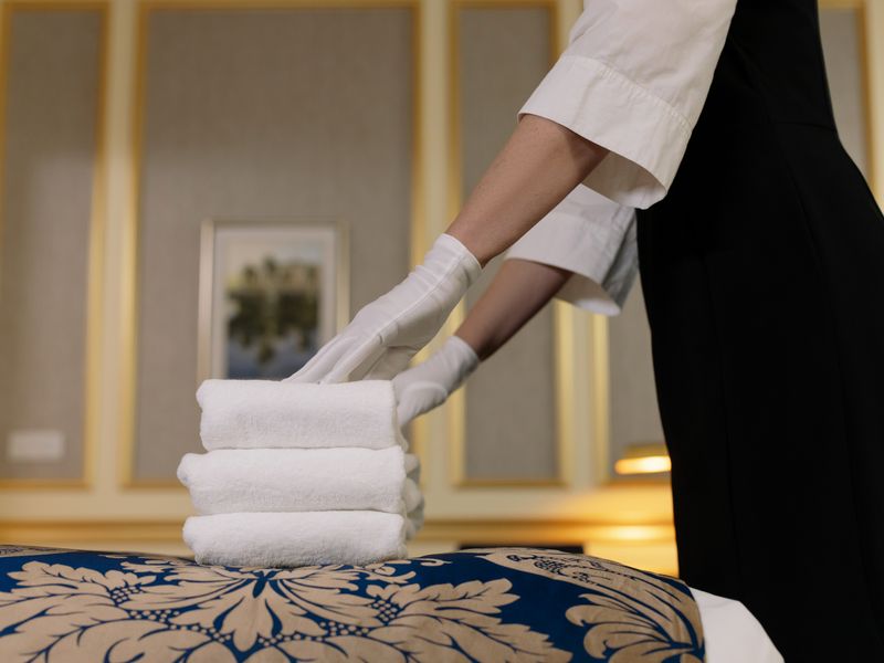 Cleaning staff member arranging fresh towels in a facility