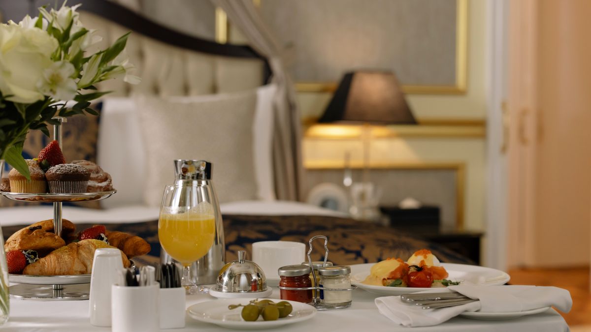 A hotel room breakfast with pastries, coffee, and orange juice