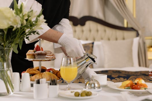 A stylish room service breakfast setup with pastries, coffee, and orange juice in a hotel room.