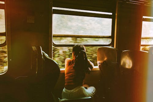 Unrecognizable woman riding train and looking out window