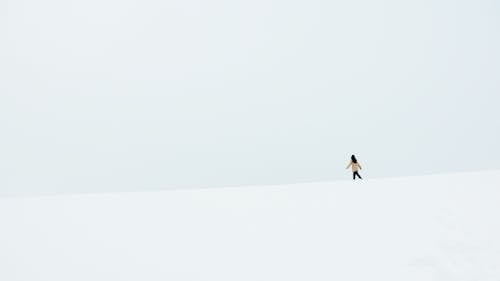 Person in Black Jacket and Pants Walking on Snow