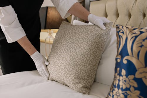 Free Woman Fixing Pillows on a Bed Stock Photo