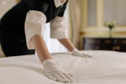 Free Woman Fixing the Linen of a Bed Stock Photo