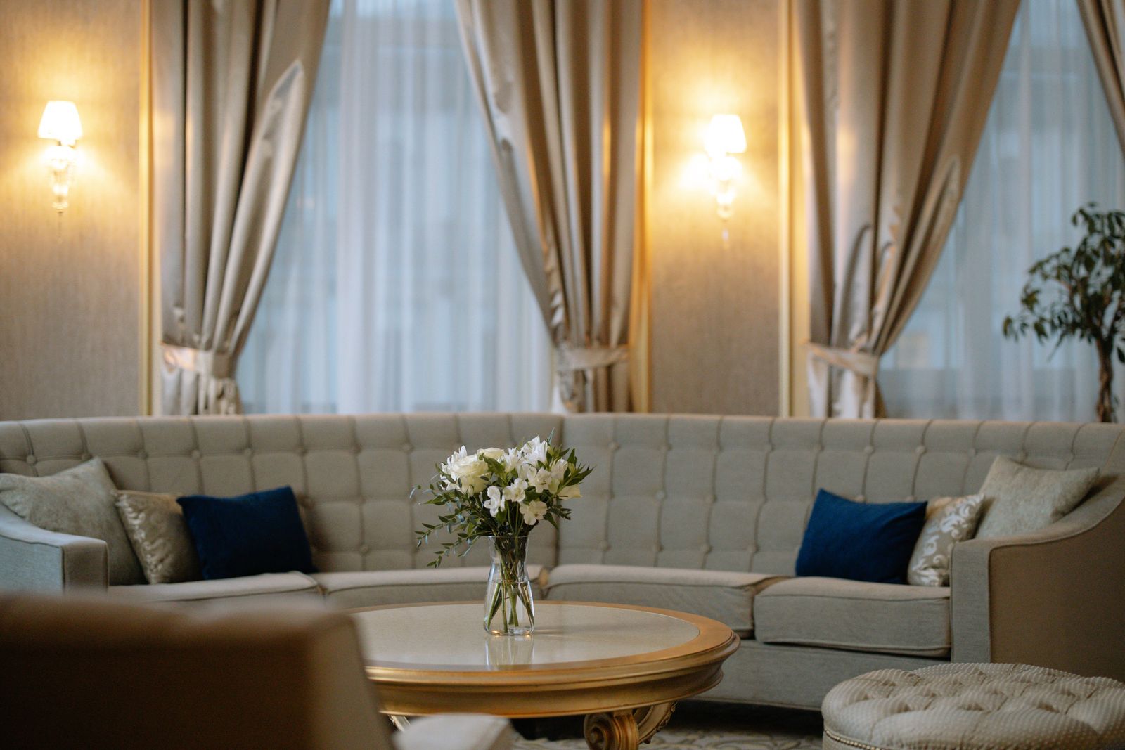Elegant suite lounge with curved sofa and fresh flowers