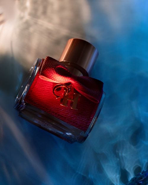 Free Top view composition on elegant perfume bottle with decorative bow placed on blurry blue surface Stock Photo