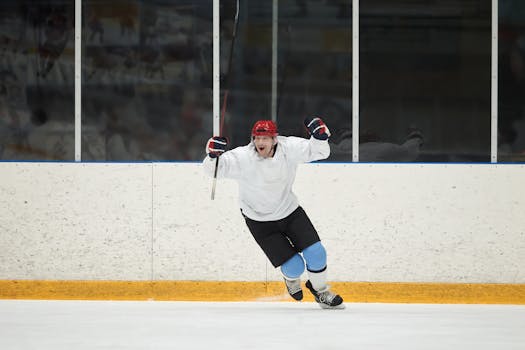 Dynamic action shot of a hockey player celebrating a victory indoors on the ice rink.