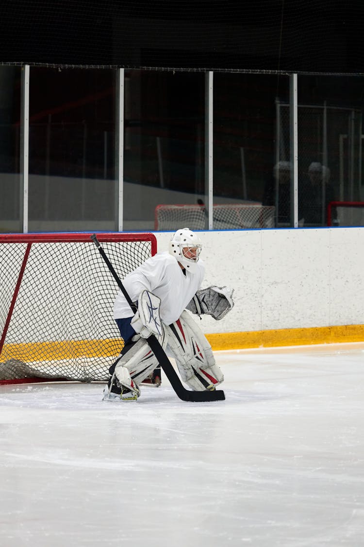 A Goaltender Standing In Front Of The Goal Post