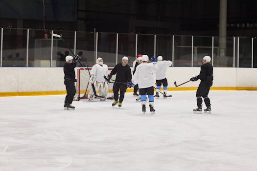 Ice hockey players in action during practice on an indoor rink, showcasing teamwork and skills.
