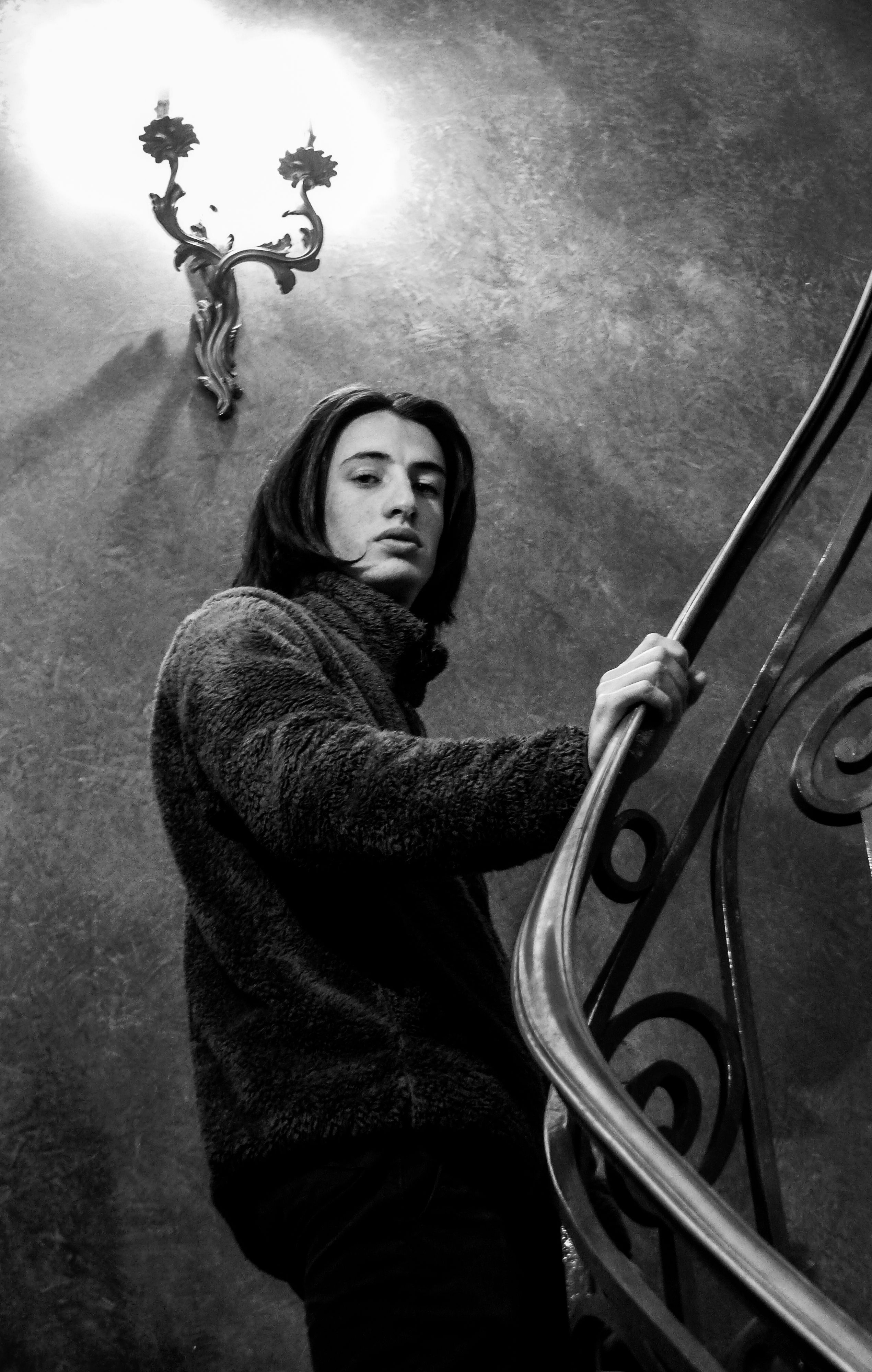 Black and white portrait of a man on a spiral staircase, Paris.
