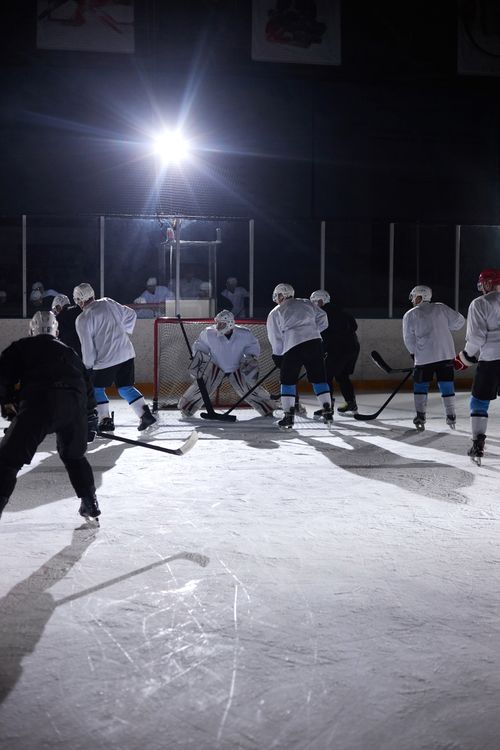 Free A team of hockey players practicing on an ice rink under bright arena lights, showcasing teamwork and sportsmanship. Stock Photo