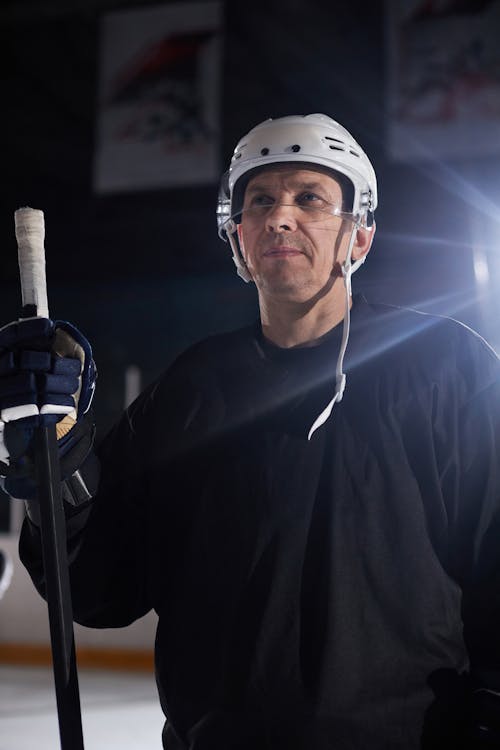 A Man Wearing a Skullcap while Holding a Hockey Stick