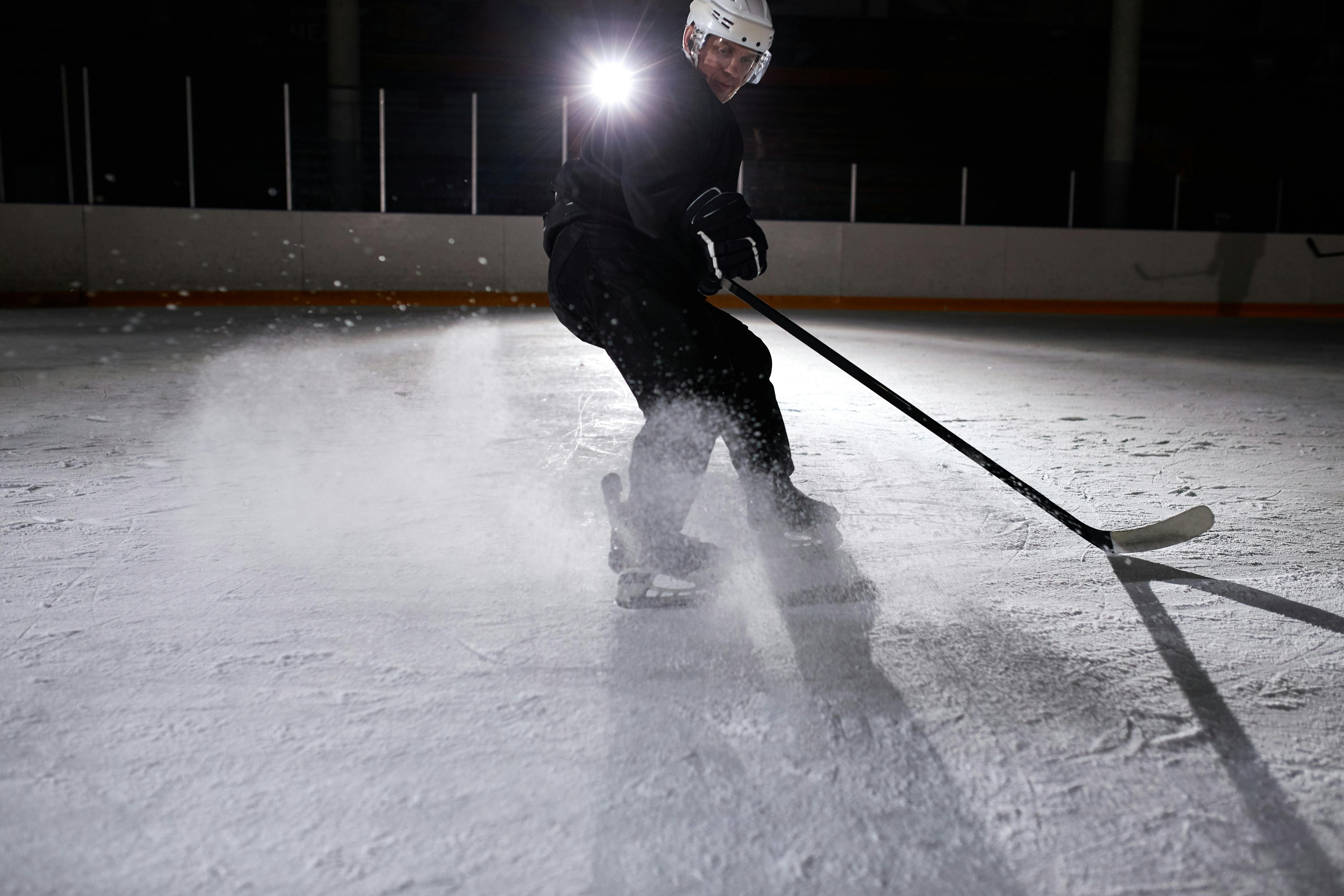 A Man in Black Jacket Playing Ice Hockey · Free Stock Photo