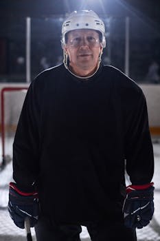 Close-up of a hockey player in full gear on an indoor ice rink.