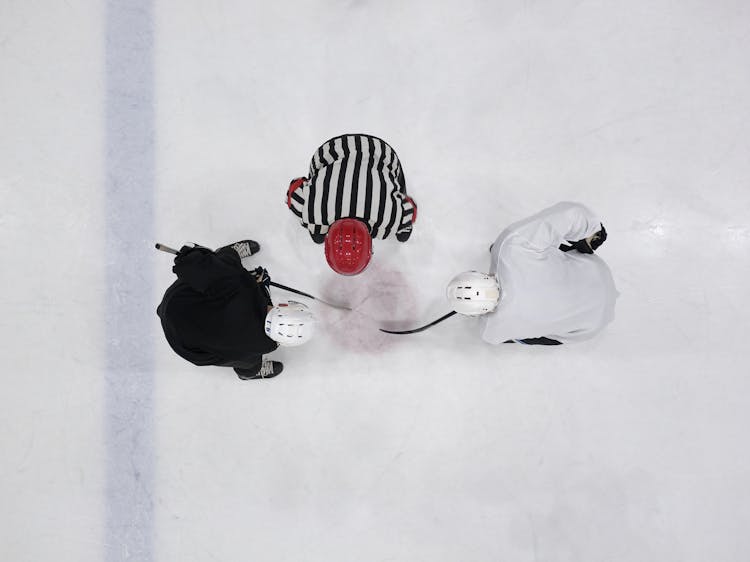 A Referee And Hockey Players On An Ice Rink