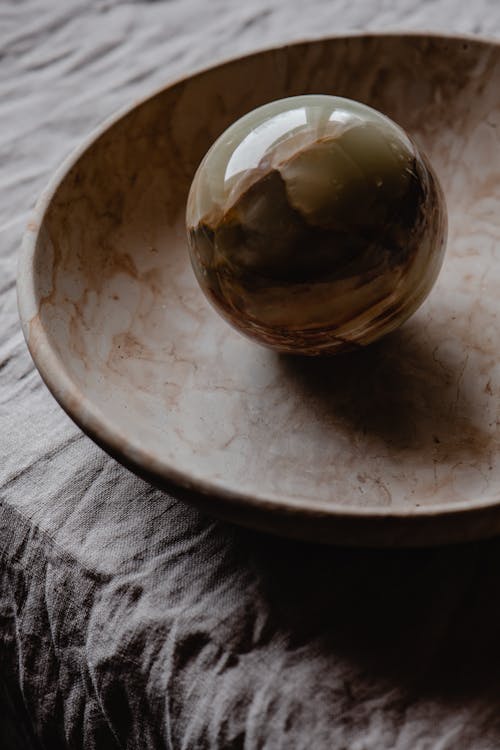 Gold Ball on Brown Ceramic Plate