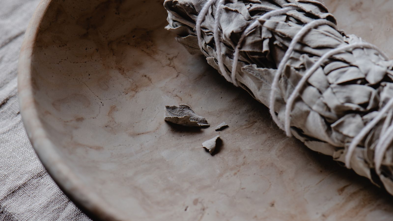 White sage smudge stick on a ceramic plate ready for an energy clearing ritual