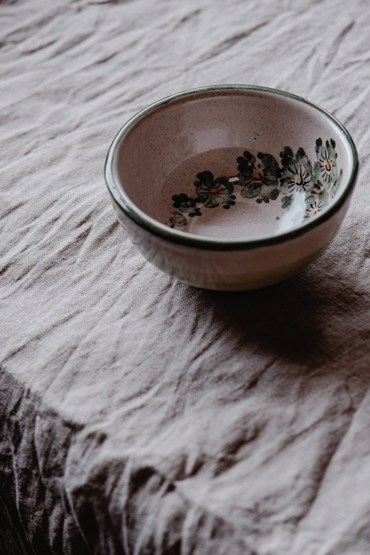 A Ceramic Bowl With Painted Flowers Inside