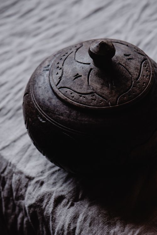 Free A close-up of an intricately carved antique wooden box against a textured fabric background. Stock Photo