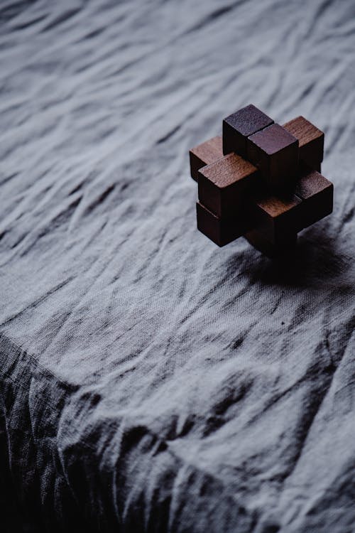 Cubo Di Legno Marrone Su Tessuto Grigio