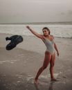 Woman in Stripes One Piece Swimsuit Standing on Beach