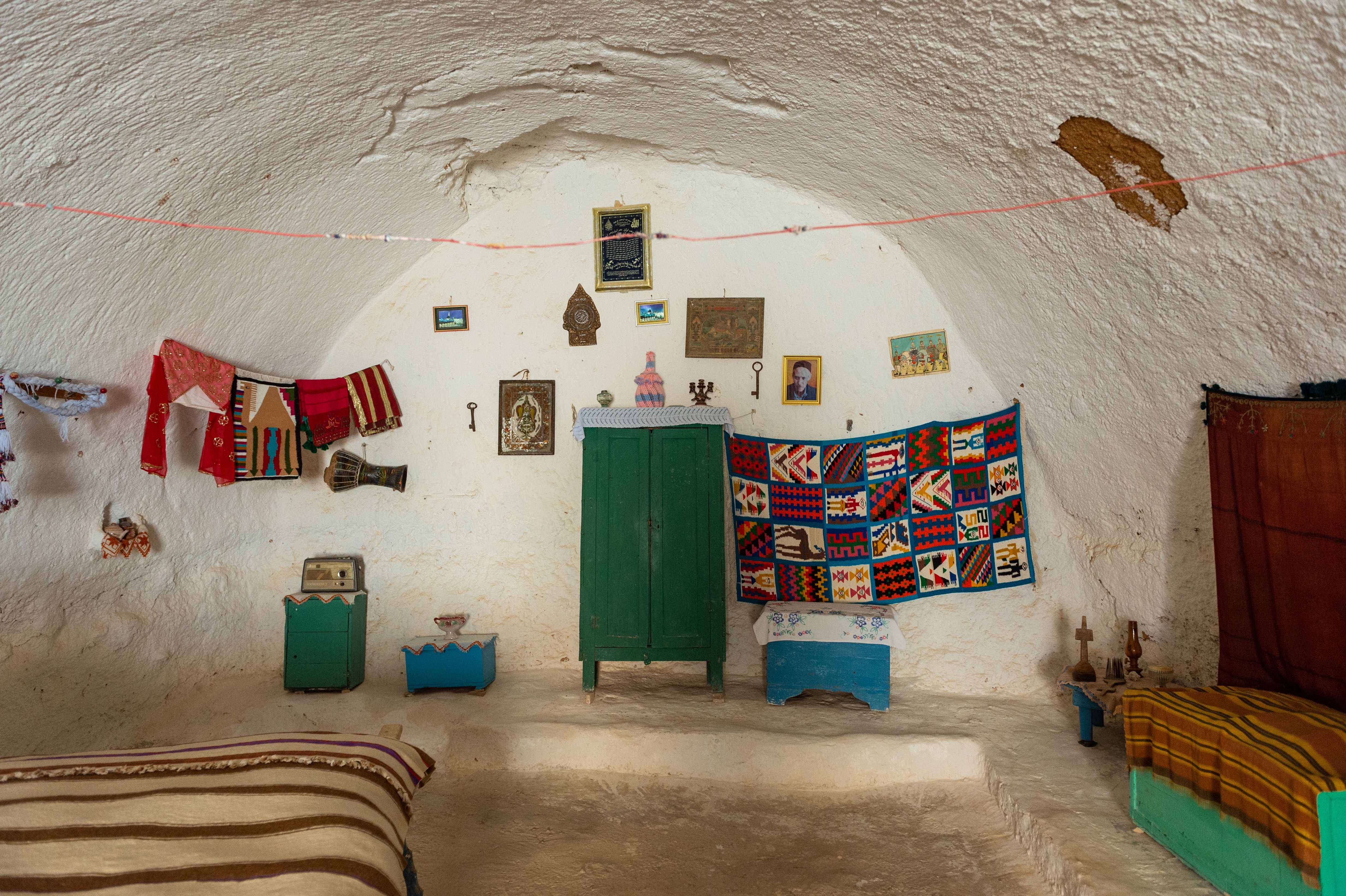 Explore a unique Tunisian cave interior with vibrant decor and traditional furnishings.