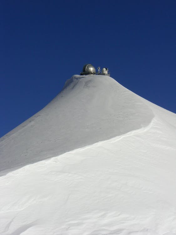 Kostenlos Graues Rundes Wettergerät Auf Dem Schneebedeckten Berg Während Des Tages Stock-Foto