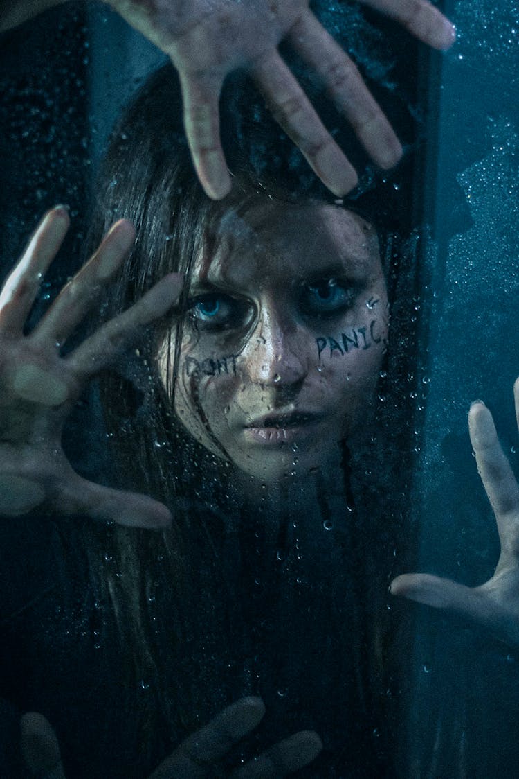 Girl With Wet Hair And Smudged Makeup Holding Her Hands On A Wet Window 