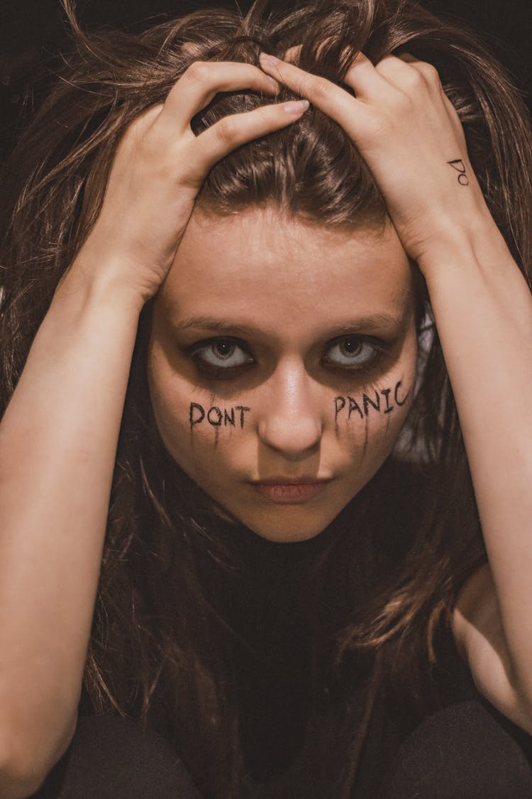 Close-up Of A Woman With The Phrase Don't Panic Written On Her Face