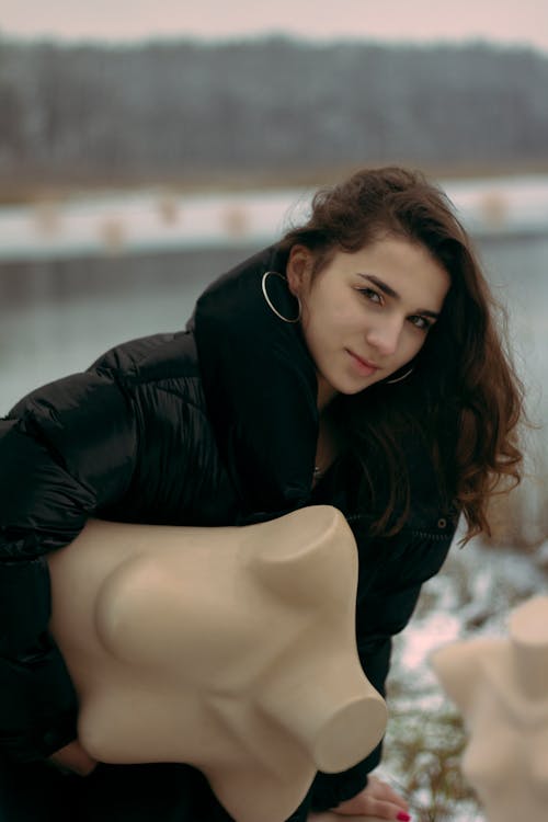 Free A Pretty Woman Posing while Holding a Mannequin Stock Photo
